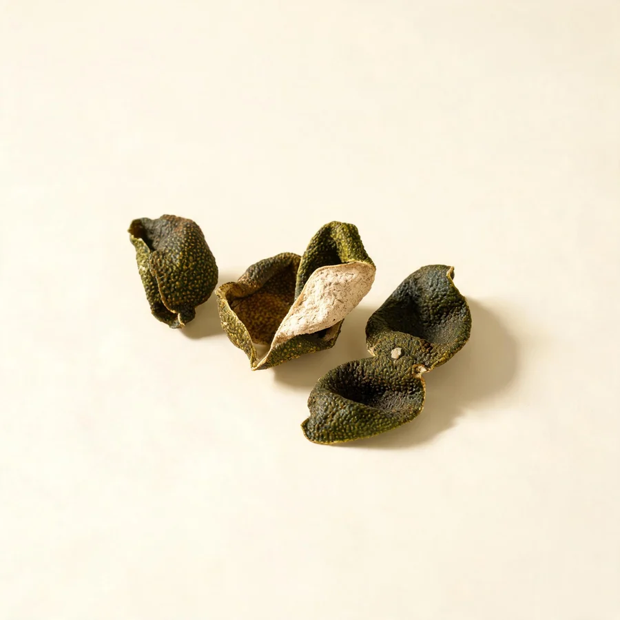 Dried Qing Pi peel of unripe fruit arranged in a shallow bowl